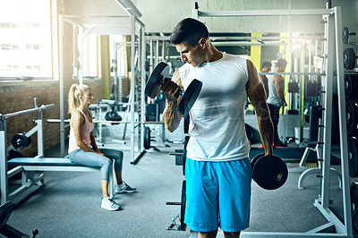 Buy stock photo Shot of a young man working out alone in the gym