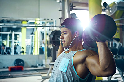 Buy stock photo Shot of a man doing a upper-body workout at the gym