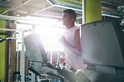 Buy stock photo Shot of a young man working out alone in the gym