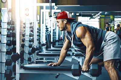 Buy stock photo Shot of a young man working out alone in the gym