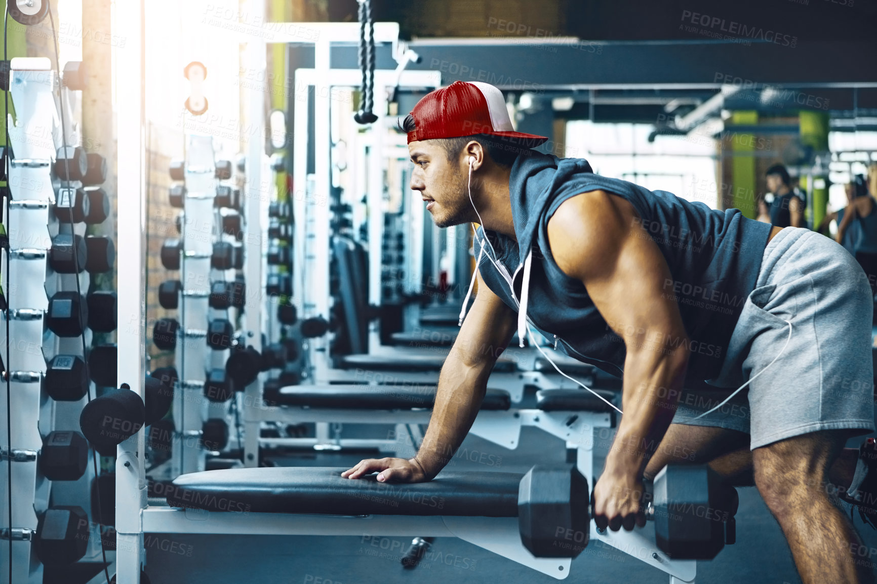 Buy stock photo Shot of a young man working out alone in the gym