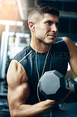 Buy stock photo Shot of a young man working out alone in the gym