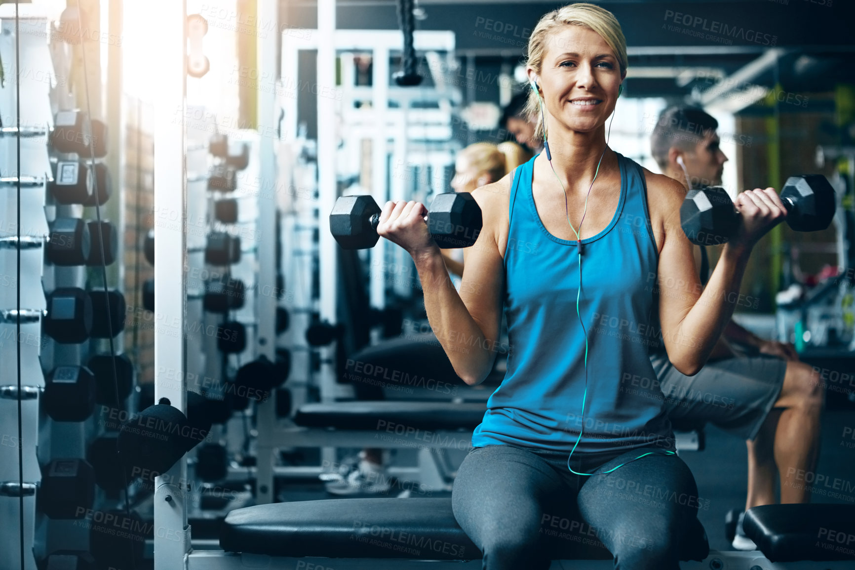 Buy stock photo Woman, earphones and dumbbells in gym for fitness, strength training or endurance exercise. People, athlete or weights at wellness club for weightlifting, muscle growth or workout with music playlist