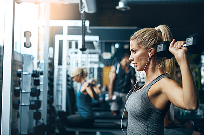 Buy stock photo Shot of a woman doing weight exercises at the gym