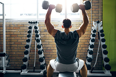 Buy stock photo Shot of a man doing a upper-body workout at the gym