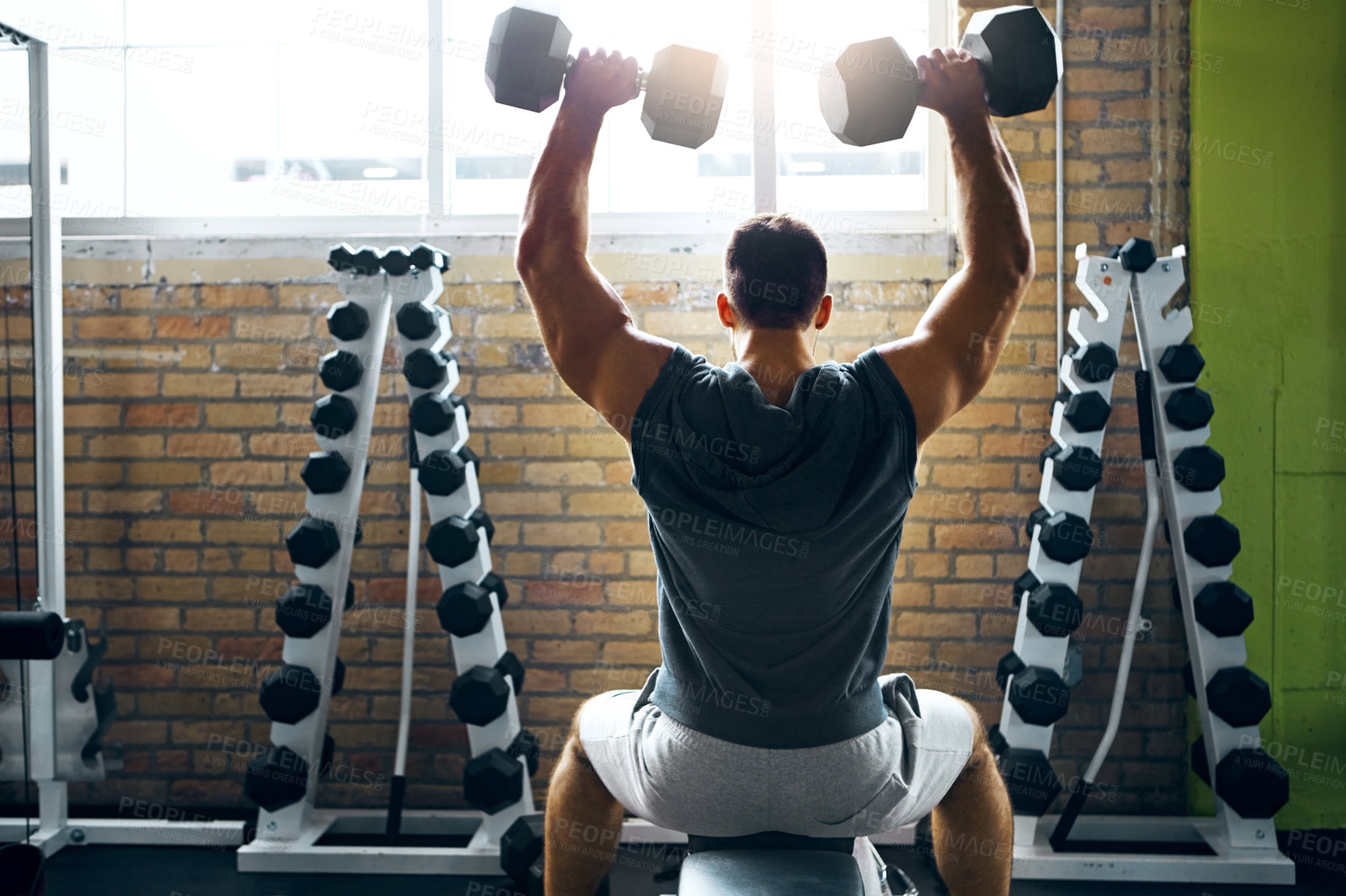 Buy stock photo Shot of a man doing a upper-body workout at the gym