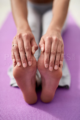 Buy stock photo Shot of a young woman touching her toes while practicing yoga outside on a sunny day