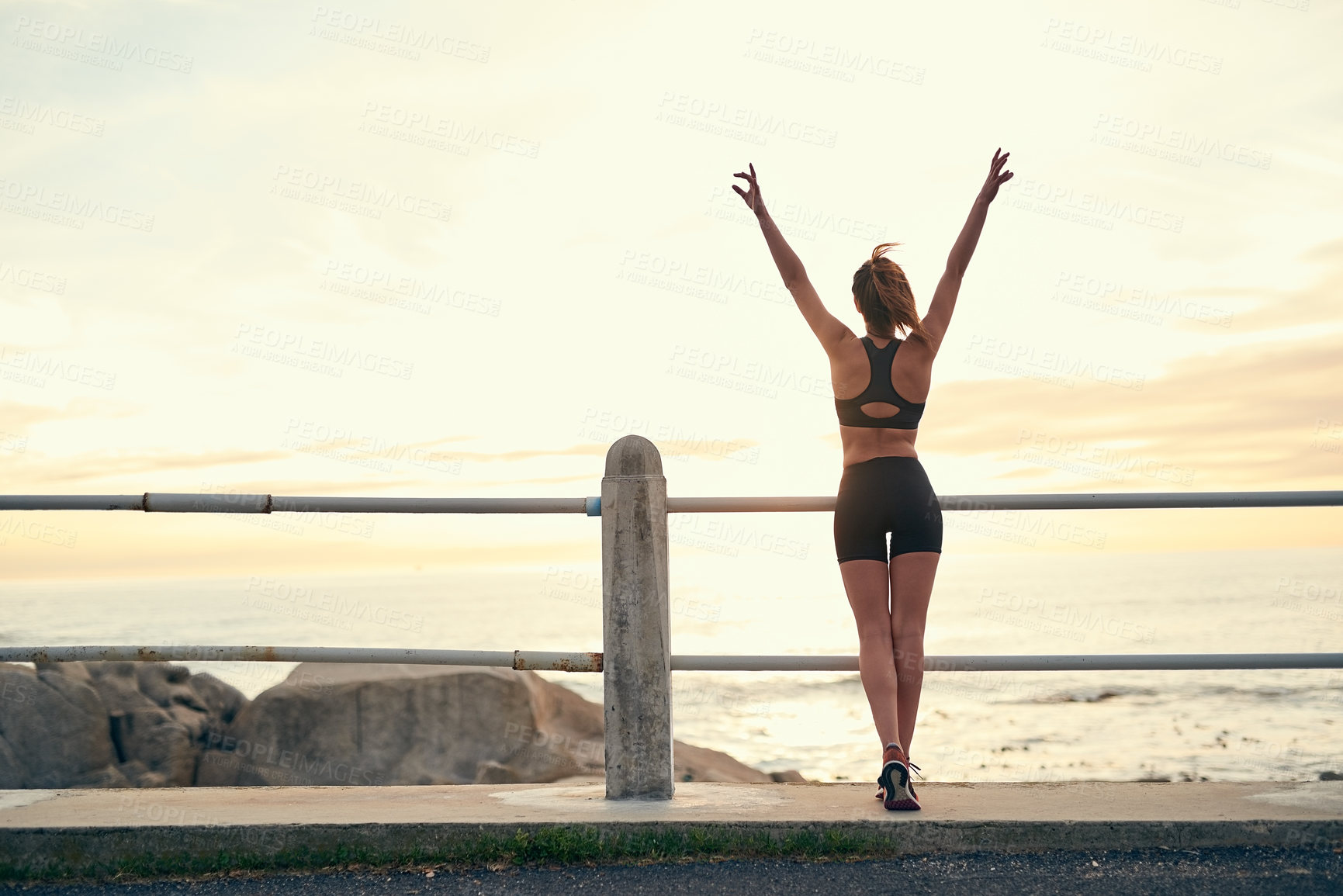 Buy stock photo Woman, sunset and arms in air at beach for fitness, exercise and freedom in summer. Female runner, celebration and success in nature for workout, training and ocean with achievement for wellness