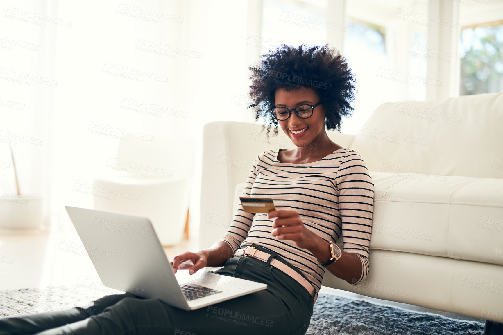 Buy stock photo Young woman, laptop and credit card on living room rug doing online shopping sitting on ground. Home, happiness and computer with African female person on a ecommerce app reading information to buy
