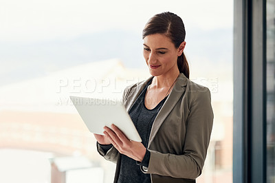 Buy stock photo Cropped shot of a young businesswoman working on a digital tablet in an office