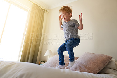 Buy stock photo Shot of a young boy jumping on a bed at home