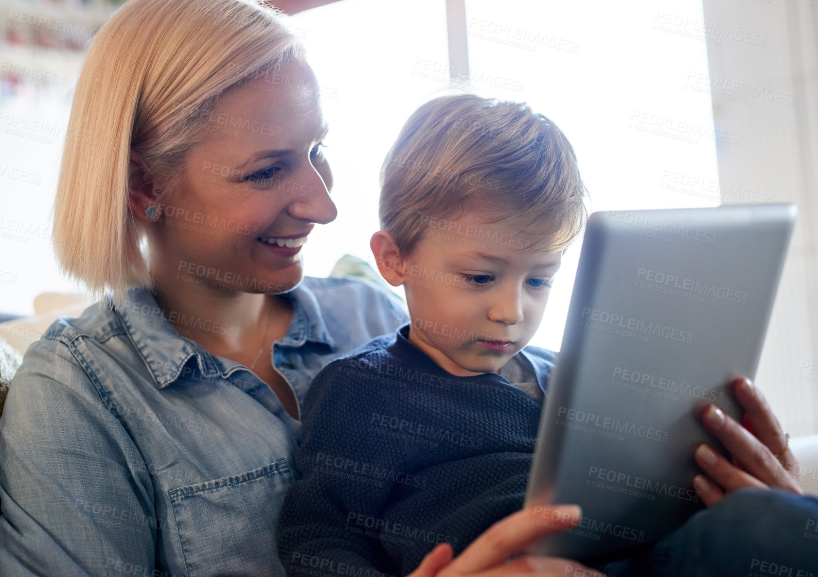 Buy stock photo Cropped shot of a mother and son using a digital tablet together at home