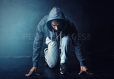 Buy stock photo Running, start and man in studio with challenge, health and wellness in hoodie at gym workout. Fitness, ready and confident runner with marathon training, commitment and exercise on dark background