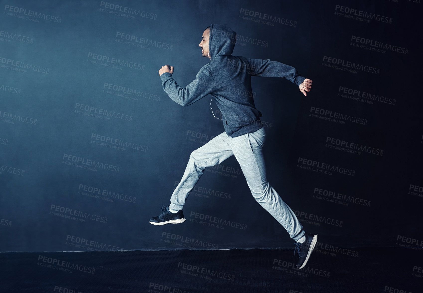 Buy stock photo Studio shot of a sporty young man running against a dark background