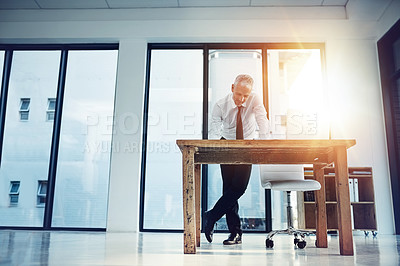 Buy stock photo Shot of a businessman working at his desk in an office