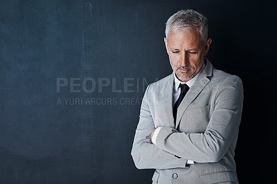 Buy stock photo Studio shot of a mature businessman looking depressed against a dark background