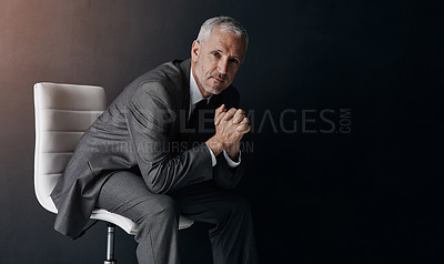 Buy stock photo Portrait, manager or corporate with a business man sitting on a chair in studio against a dark background. Leadership, management and a senior male CEO in a professional suit for his executive career