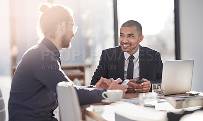 Buy stock photo Shot of two young businessmen having a discussion in a modern office