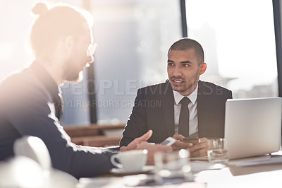 Buy stock photo Shot of two young businessmen having a discussion in a modern office