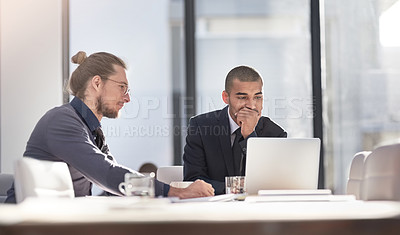 Buy stock photo Shot of two young businessmen using a laptop together at work
