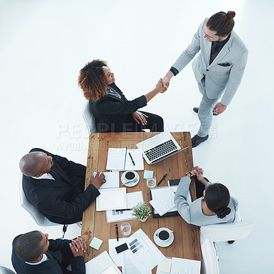 Buy stock photo Shot of two businesspeople shaking hands in a staff meeting