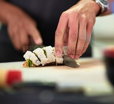 Buy stock photo Shot of an unidentifiable young man preparing sushi in his kitchen