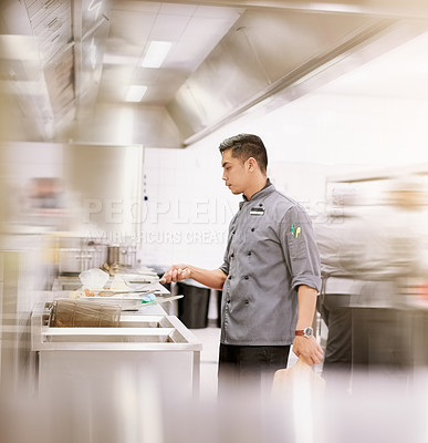 Buy stock photo Cropped shot of a young male chef cooking in his kitchen