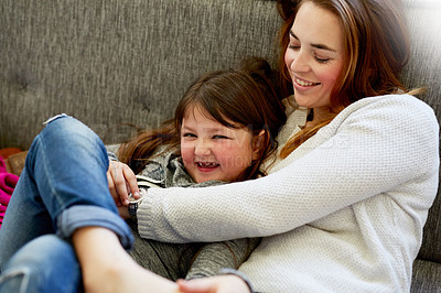 Buy stock photo Shot of a mother playing with her little girl on the couch at home