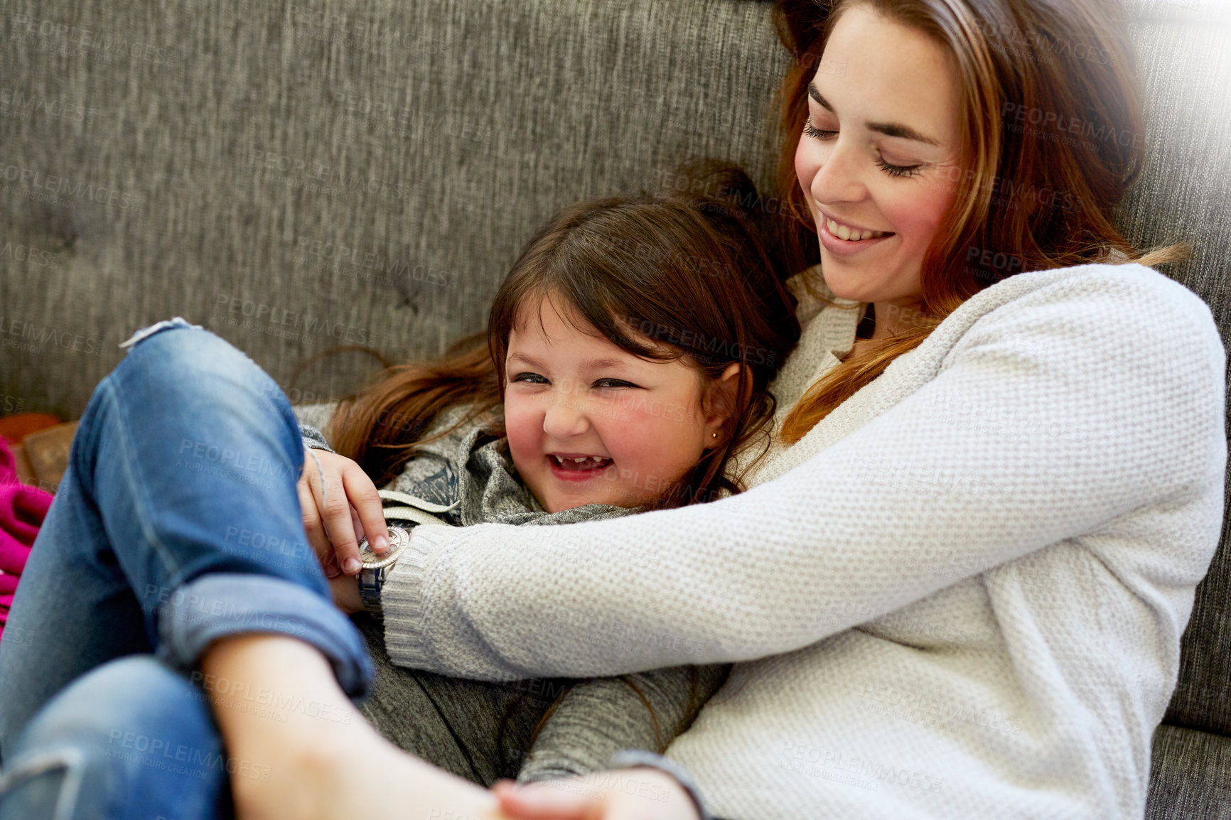 Buy stock photo Shot of a mother playing with her little girl on the couch at home