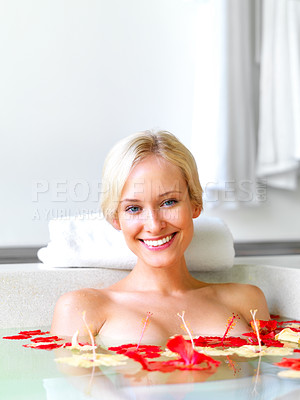 Buy stock photo Portrait of happy young lady relaxing in a bath tub with tropical flowers