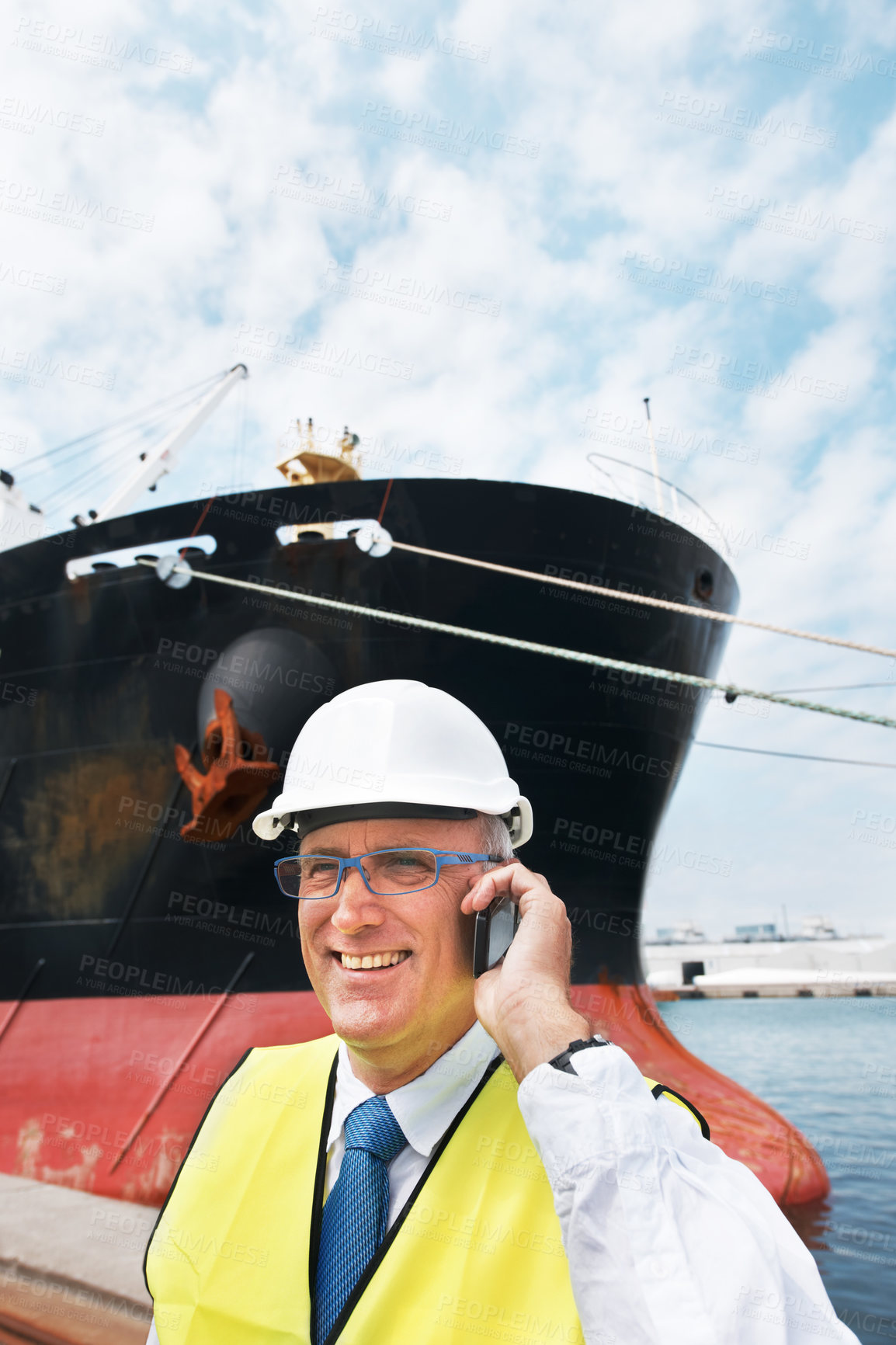 Buy stock photo A dock worker standing at the harbor amidst shipping industry activity