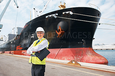 Buy stock photo A happy foreman standing with his arms crossed in front of a ship.