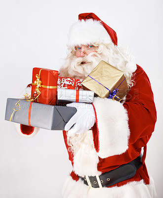 Buy stock photo Santa Claus holding a pile of wrapped christmas gifts - portrait