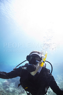 Buy stock photo Person, swimming and scuba diving in ocean to explore underwater, adventure and tropical holiday or vacation. Expert diver in Maldives with mockup space, nature and bubbles in water for sea life