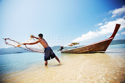 Buy stock photo Fisherman cast net, sea and man is working, nature and labor with fishing in Thailand and tropical island with boat. Ocean, job and transportation with worker in water catching fish and beach