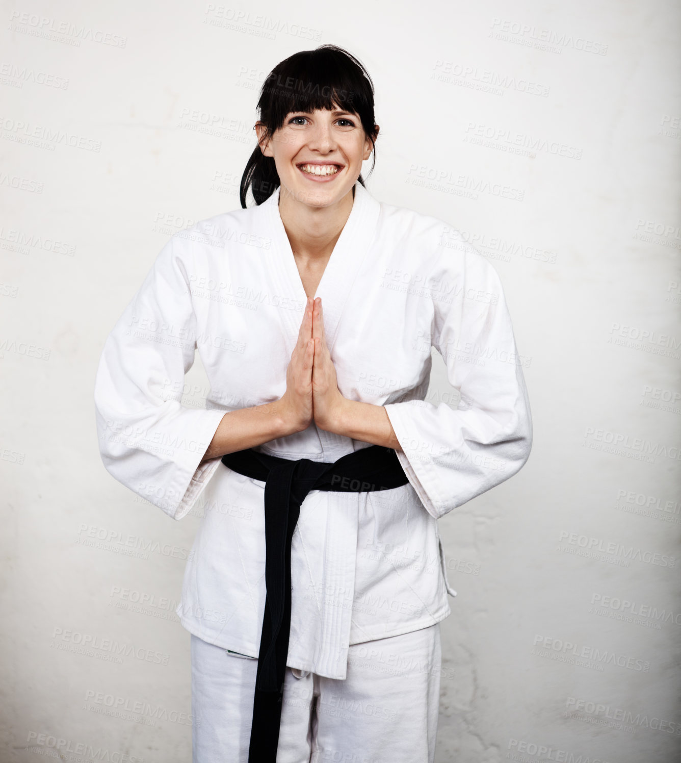 Buy stock photo Studio portrait of a young woman bowing in her karate gi