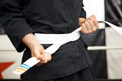 Buy stock photo Man, hands and white belt in karate of martial arts beginner, training or discipline at dojo. Closeup of male person tying gi or ranking in self defense, arena or professional fighting sport match