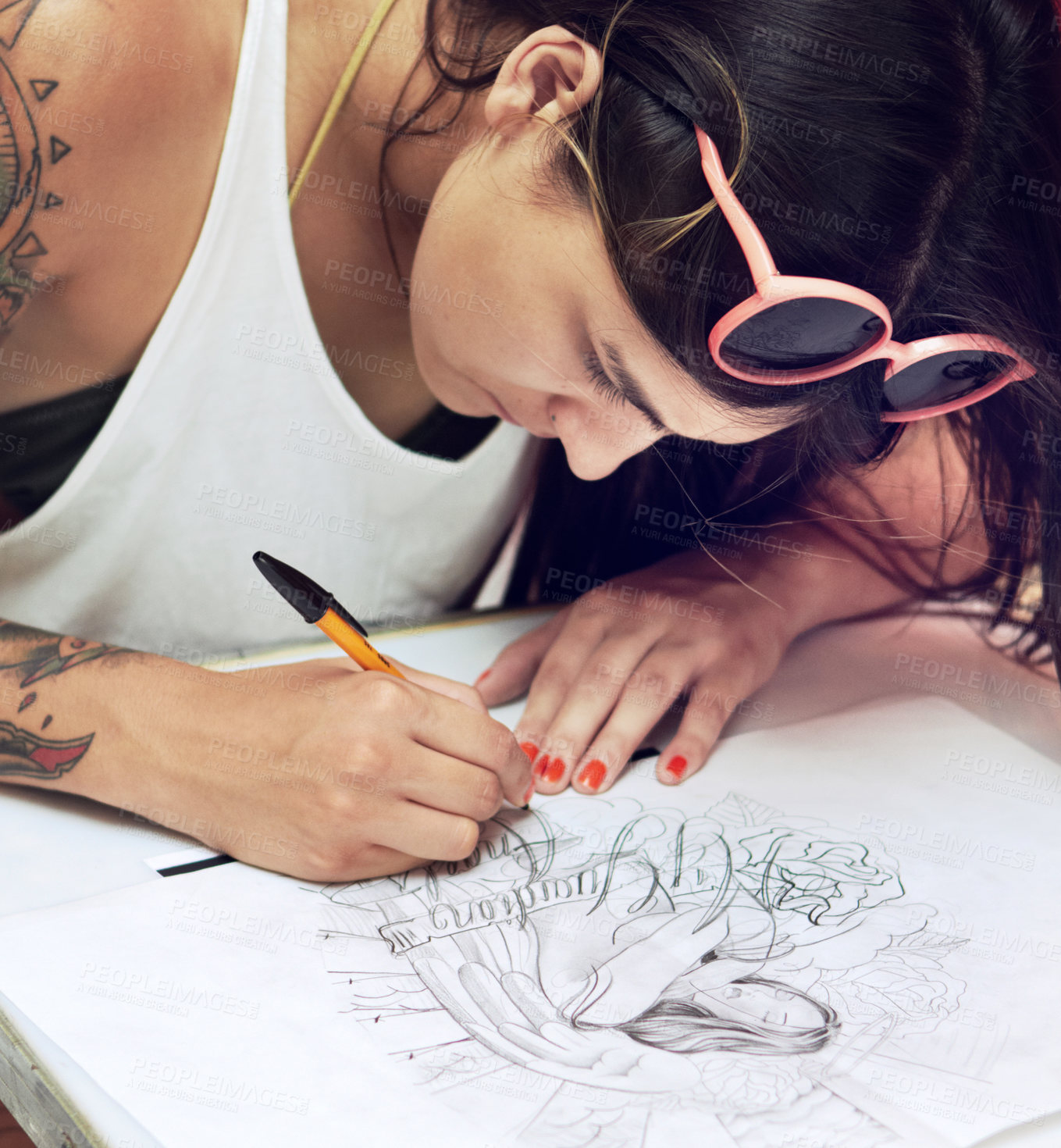 Buy stock photo Shot of a young tattoo artist sketching a drawing