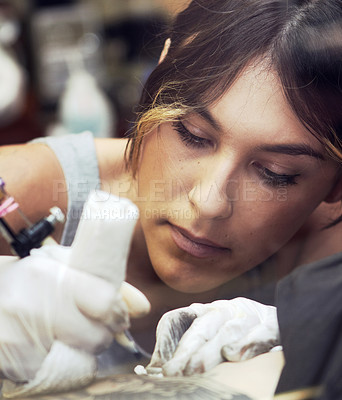 Buy stock photo Shot of a beautiful young tattoo artist at work