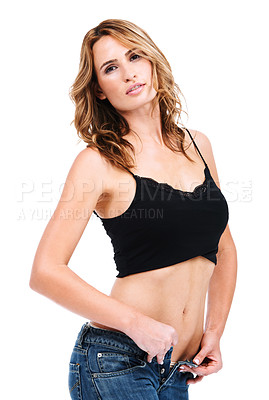 Buy stock photo Studio shot of an attractive young woman unbuttoning her jeans