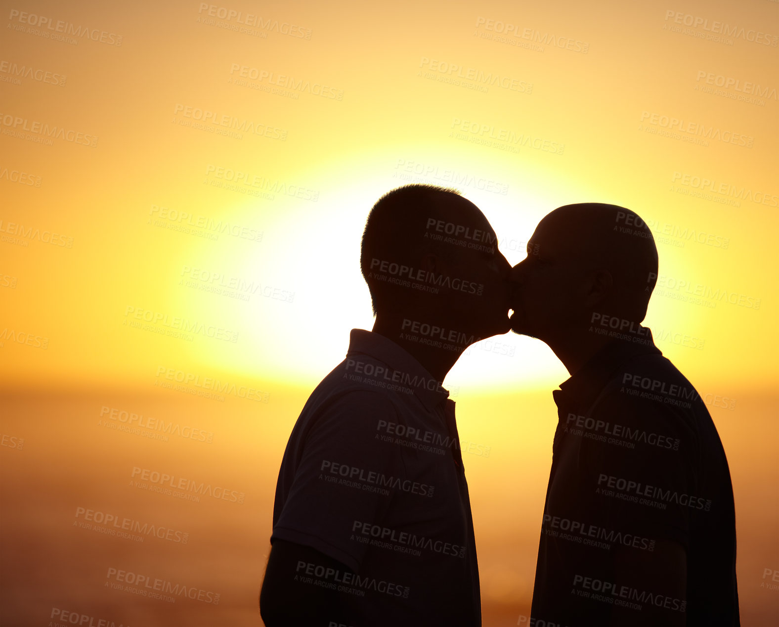 Buy stock photo Sihlouette portrait of homosexual couple kissing in front of a sunset - copyspace