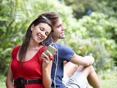 Buy stock photo Happy, love and couple relax in a forest with music, conversation and bonding outdoor. Smile, romance and people in a park for date in nature while chilling on and having fun with weekend freedom