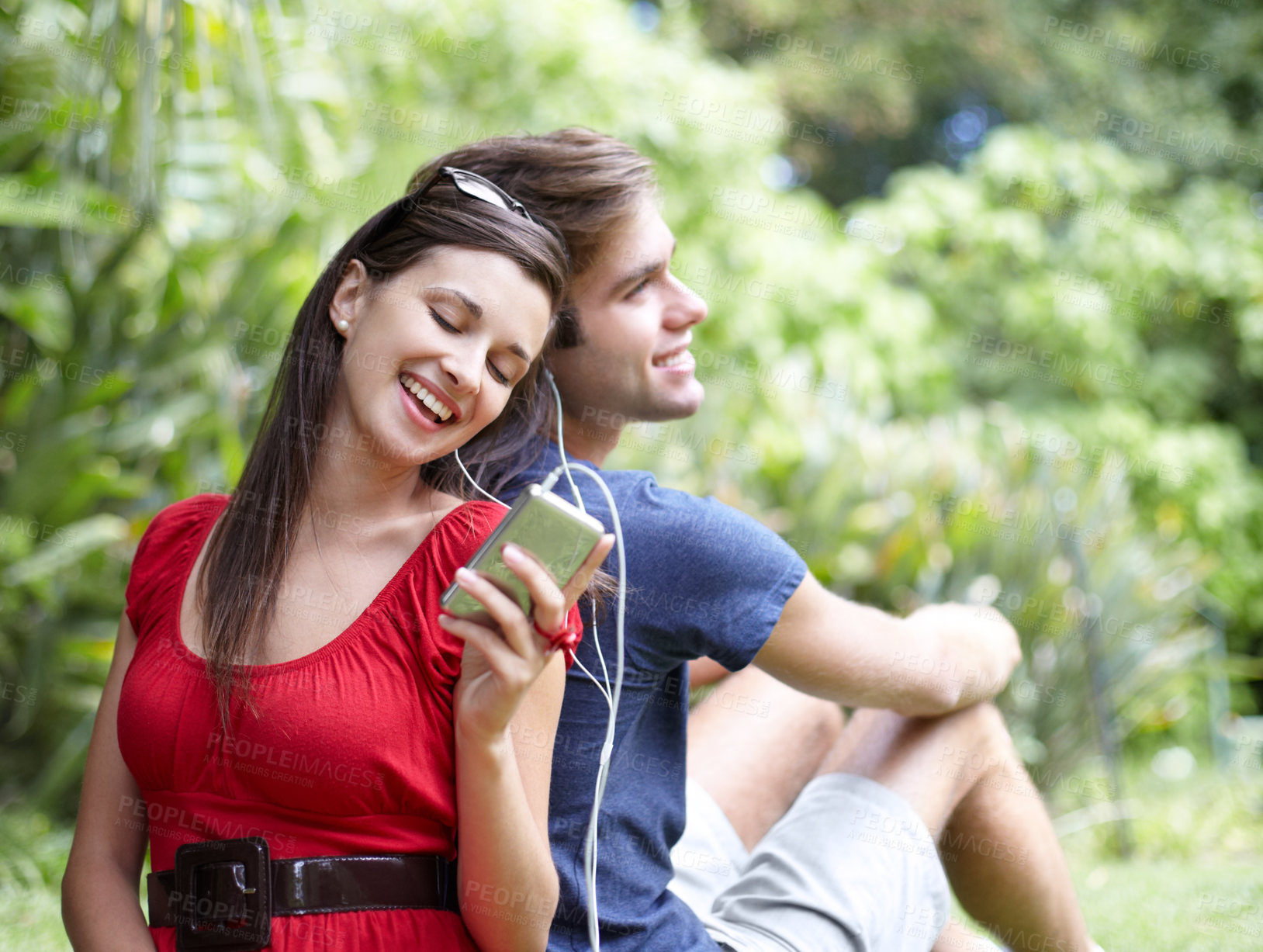 Buy stock photo Happy, love and couple relax in a forest with music, conversation and bonding outdoor. Smile, romance and people in a park for date in nature while chilling on and having fun with weekend freedom