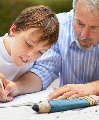 Buy stock photo Shot of a father helping his son with his homework