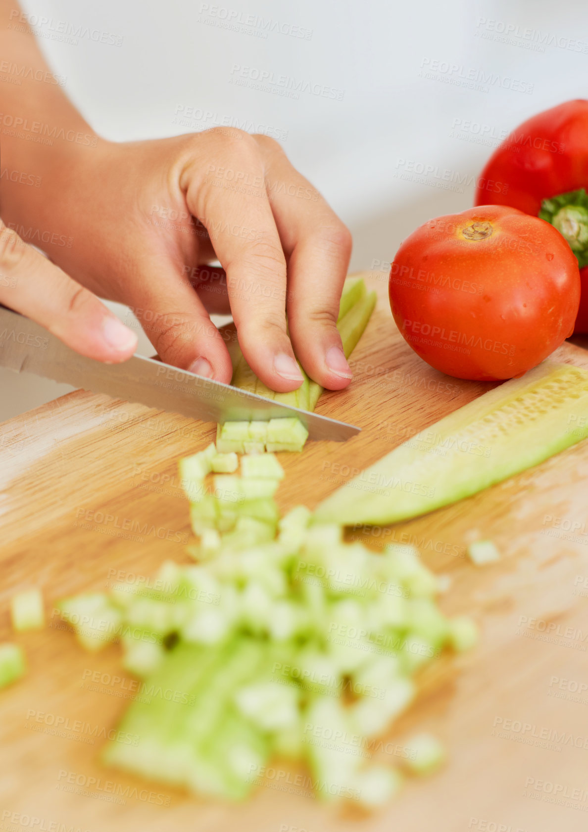 Buy stock photo Closeup of a woman chopping up a fresh cucumber