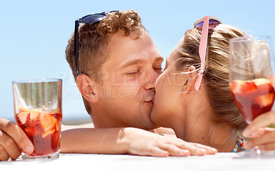 Buy stock photo A young couple kissing passionately in the hot summer sun