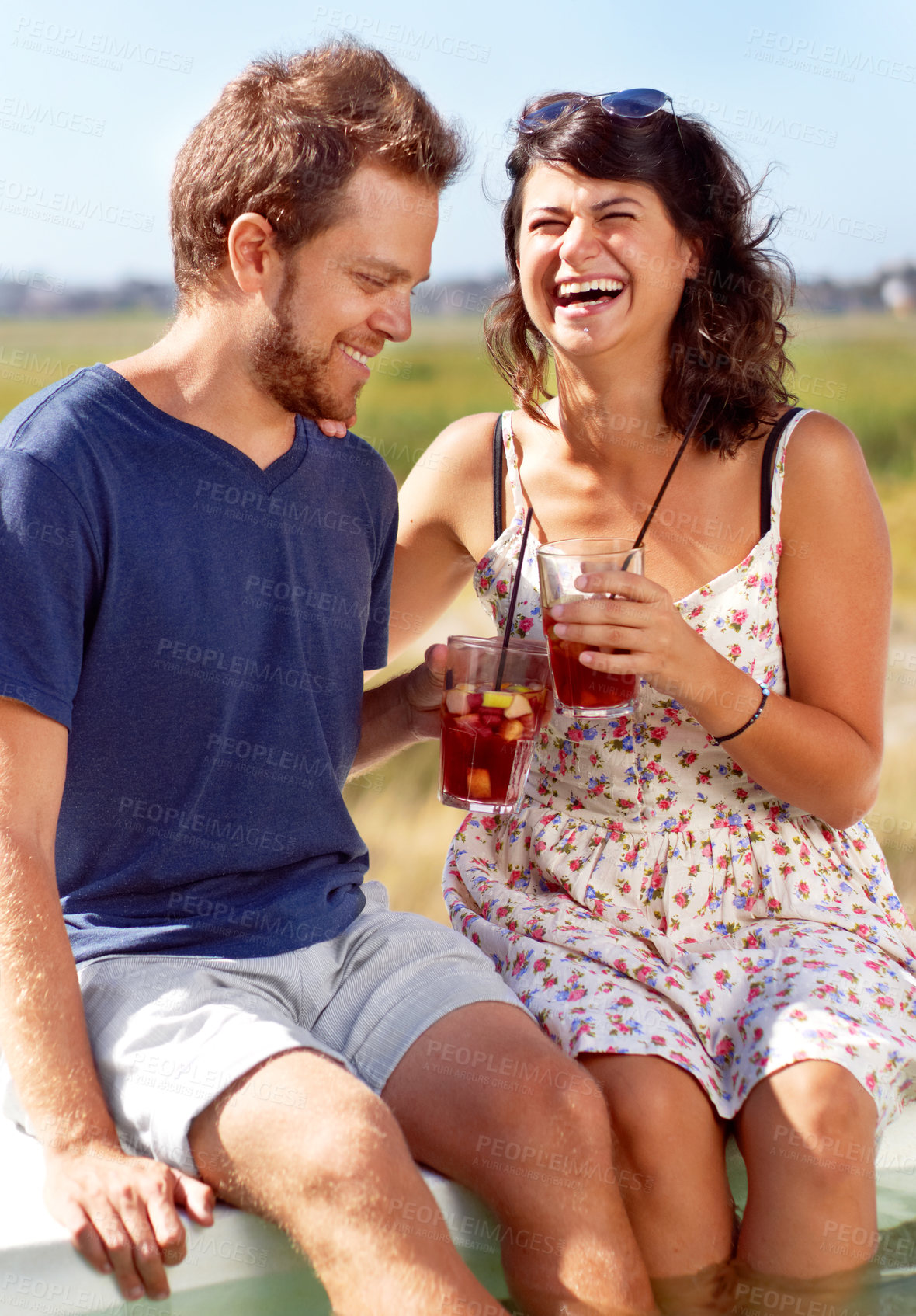 Buy stock photo A young couple toast each other on a summer's day
