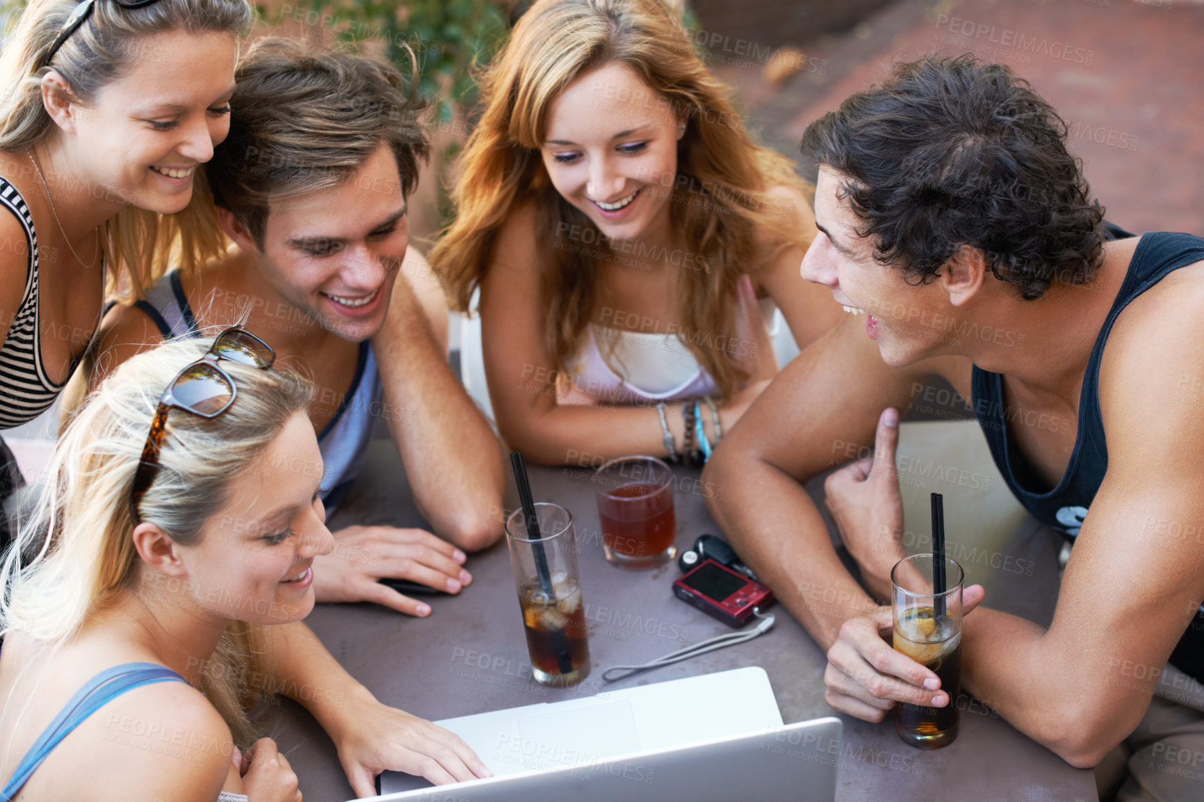 Buy stock photo Group of teens enjoying beverages while at an outdoor restaurant with all their modern technology