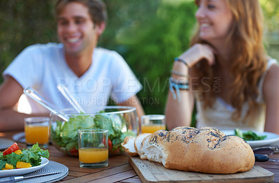 Buy stock photo Friends, bread and food in backyard for lunch and appetizer with a smile and snacks. Salad, talking and young people outdoor of a home with drinks and funny joke together with in summer with meal