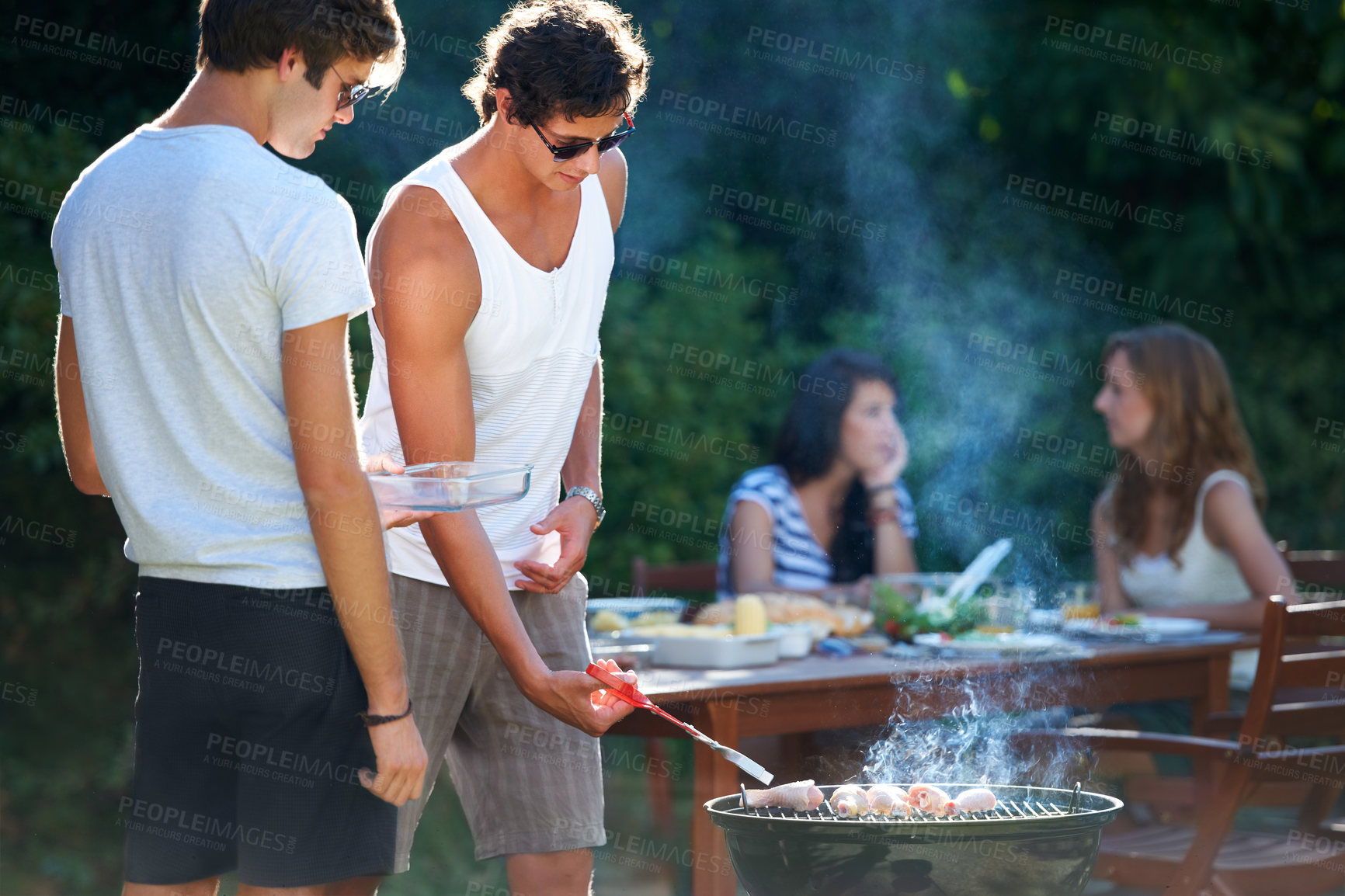 Buy stock photo Young guys barbequing meat on the grill outdoors - Lifestyle